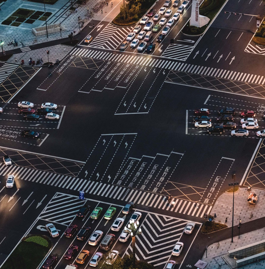 cars wait at busy intersection at night