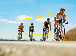 Group triathlon cyclists racing road
